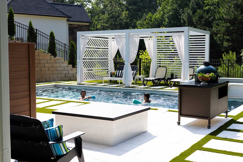 two men having fun in the pool near the white canopy