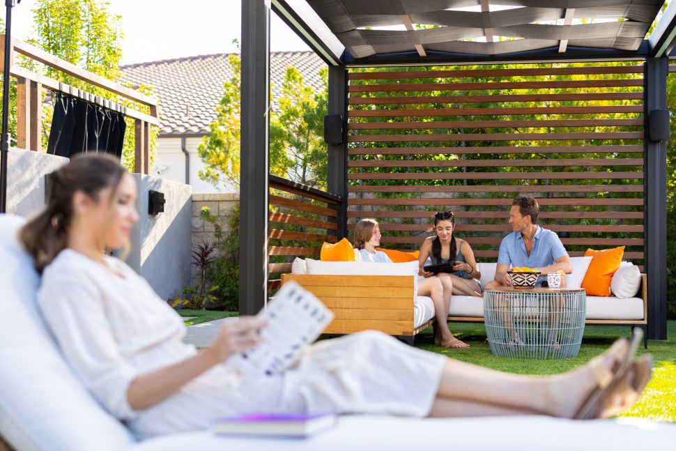 family sitting under the pergola enjoying the customized sound outdoor