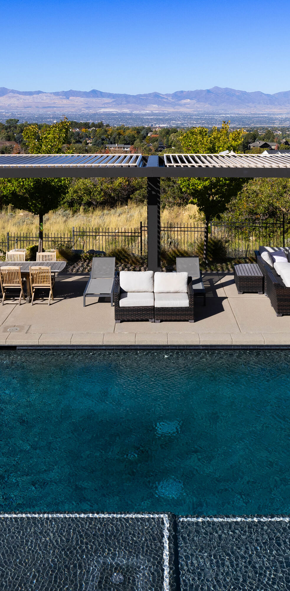 Pergola overlooking a hill near a pool.