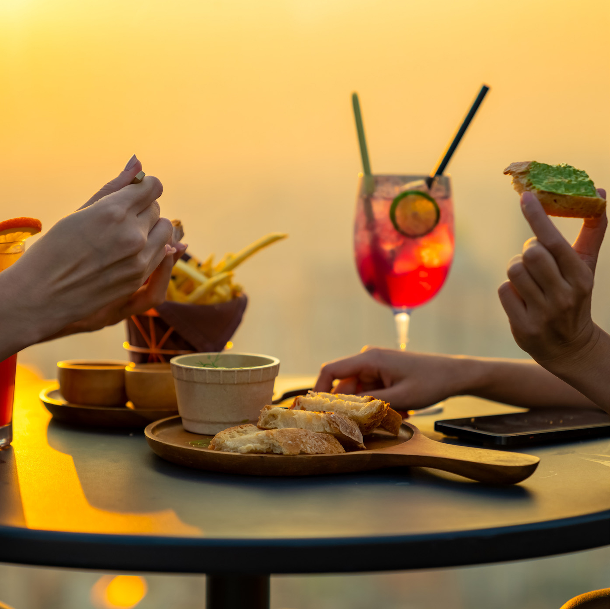 two woman eating bread with cocktail drink