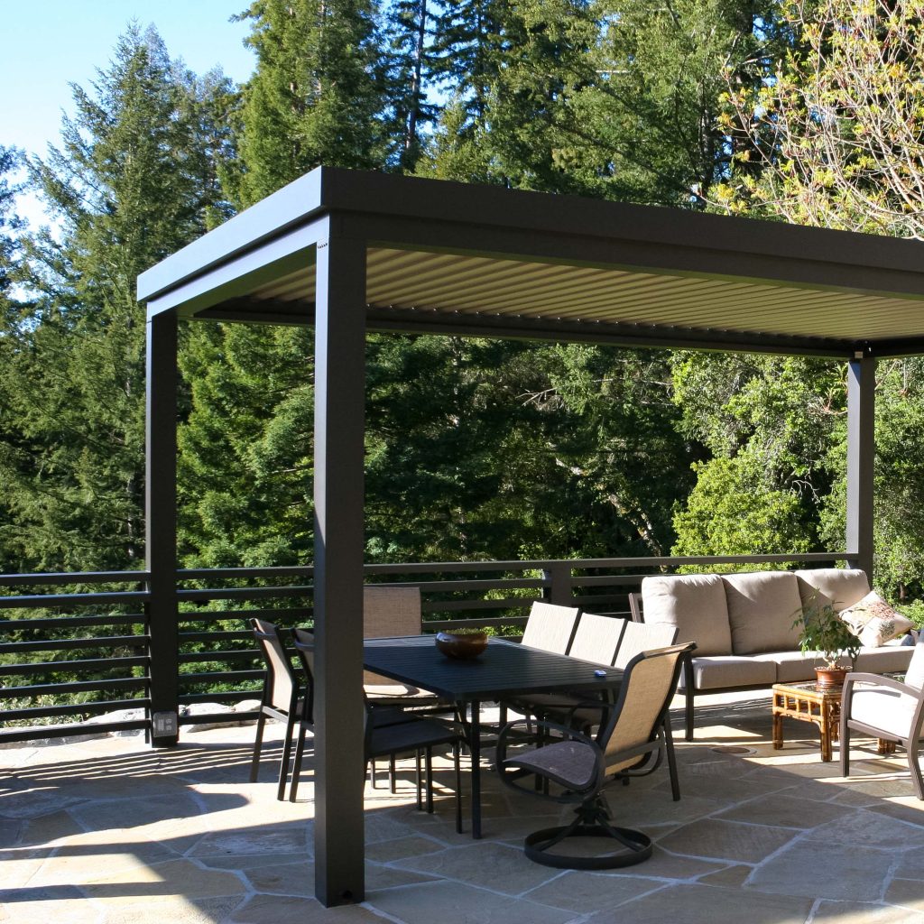 Modern patio with pergola, outdoor seating, and forest view—perfect for backyard design inspiration.