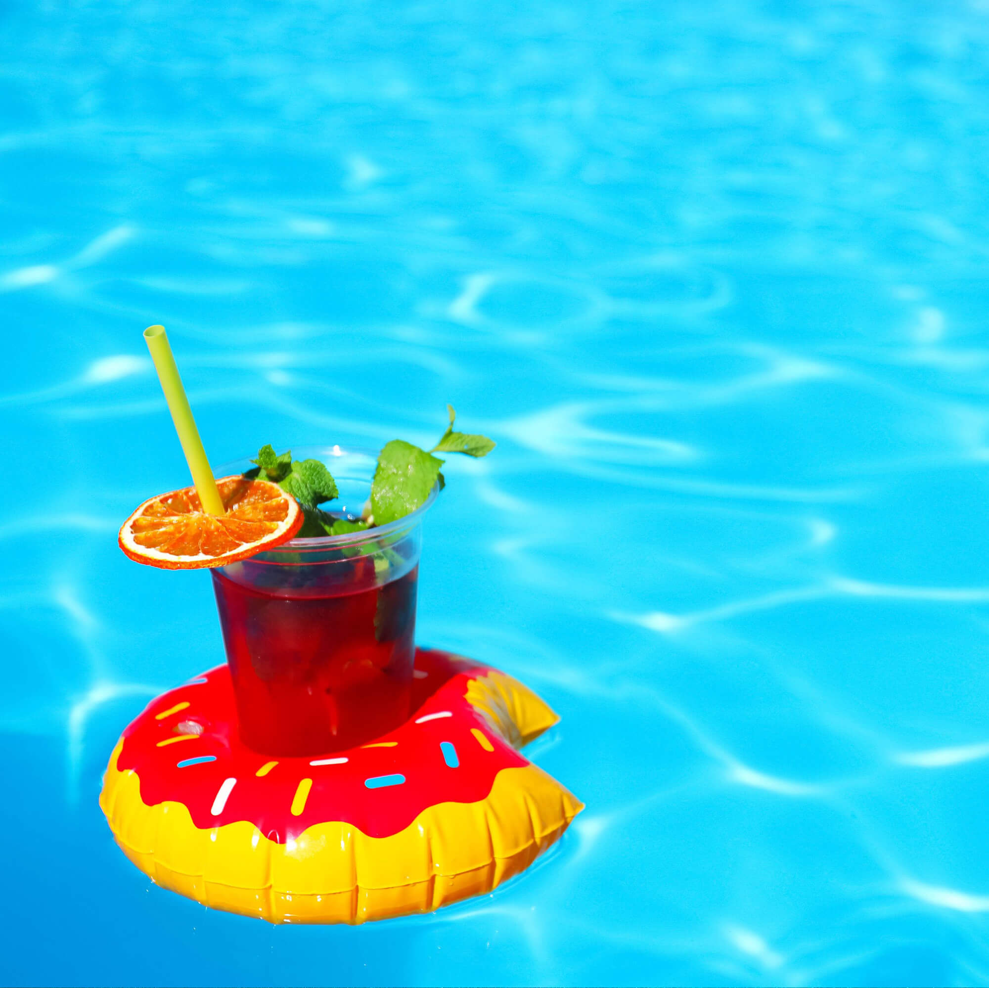 A tropical drink floating inside of a pool