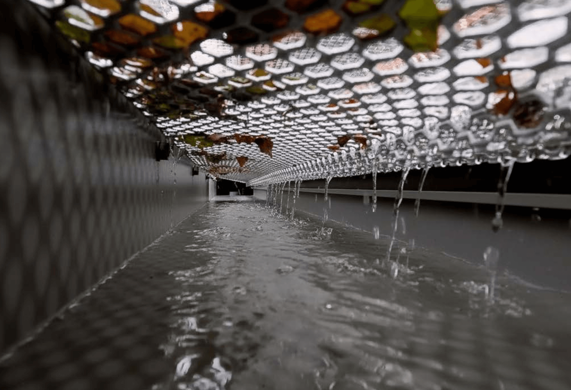 Water flowing into a gutter equipped with a gutter guard during rainfall