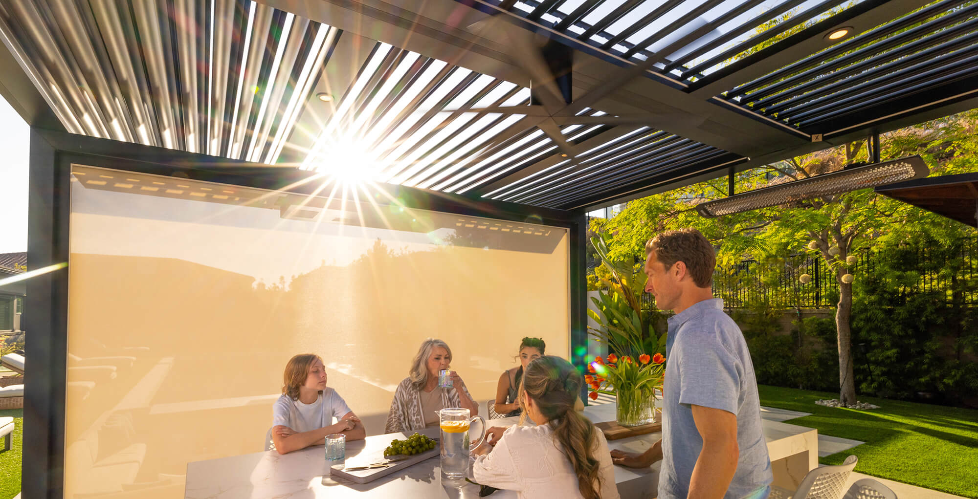 Family eating together under a pergola.