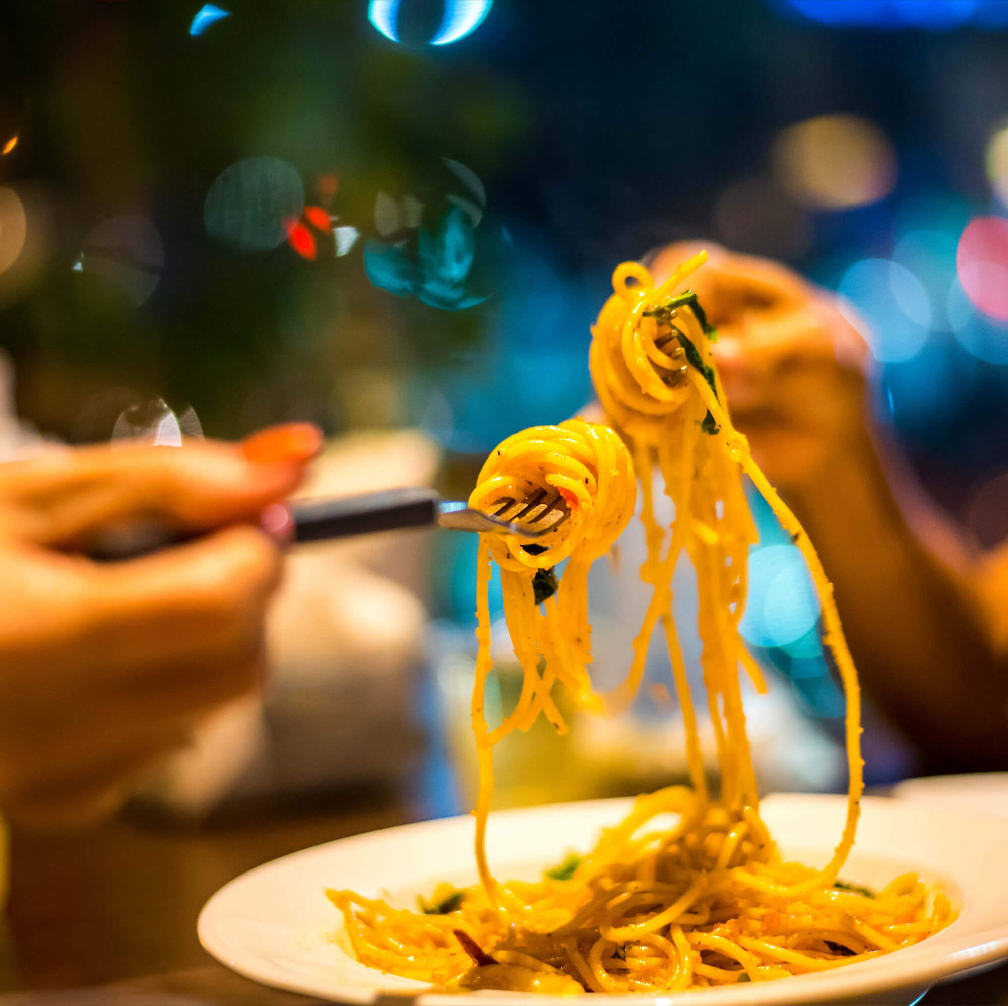 Two people sharing pasta together