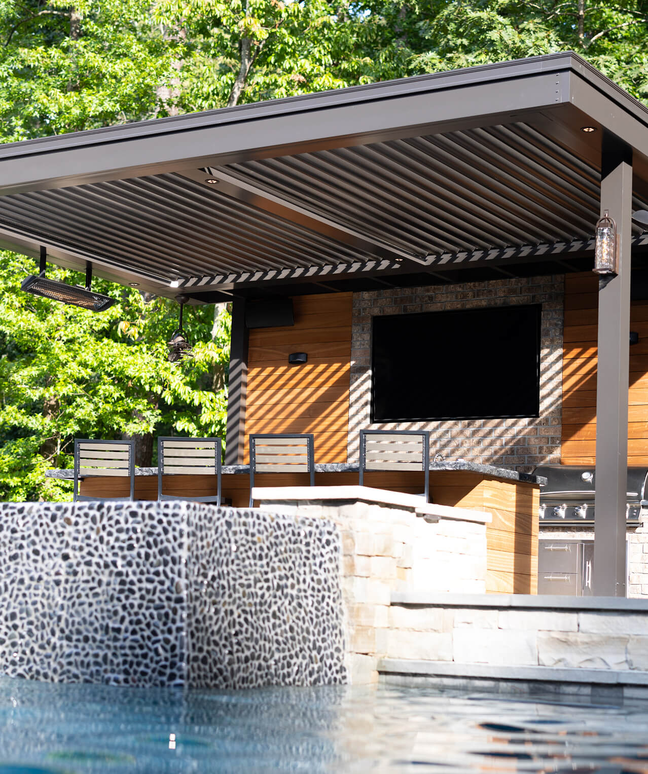 Pergola sitting poolside over an outdoor kitchen
