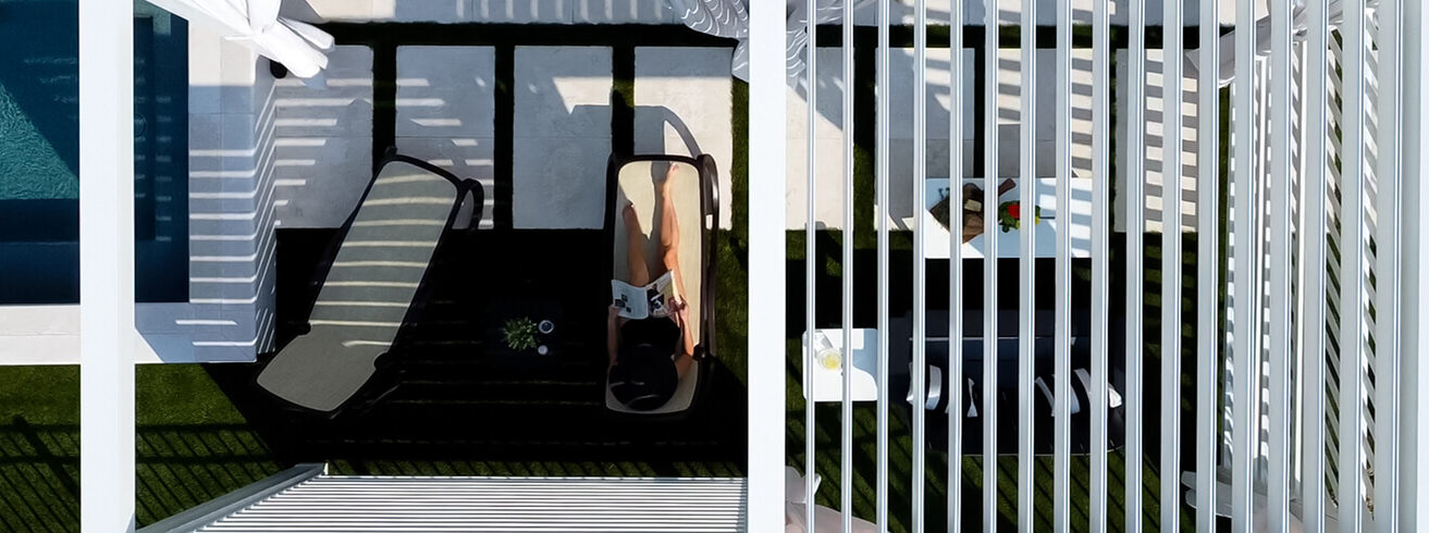 Overhead shot of white Cabana X in backyard with lounge chairs and pool