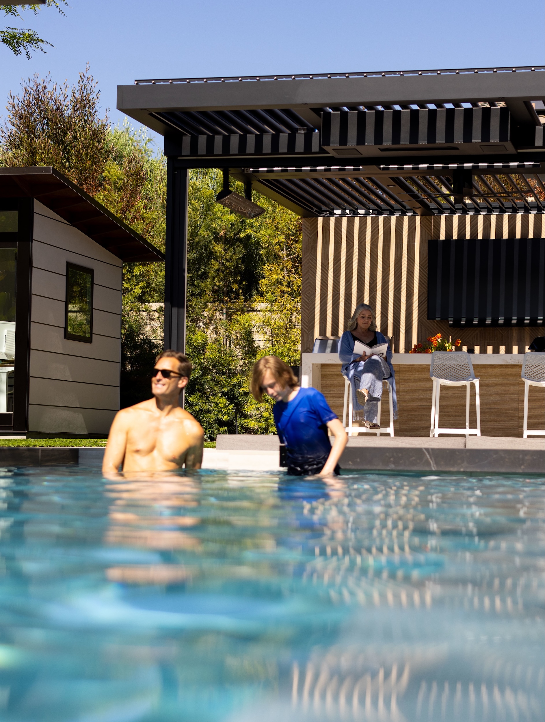 People in pool in front of a Pergola X