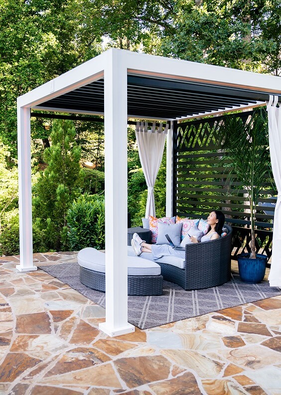 woman sitting under white and black Cabana X relaxing