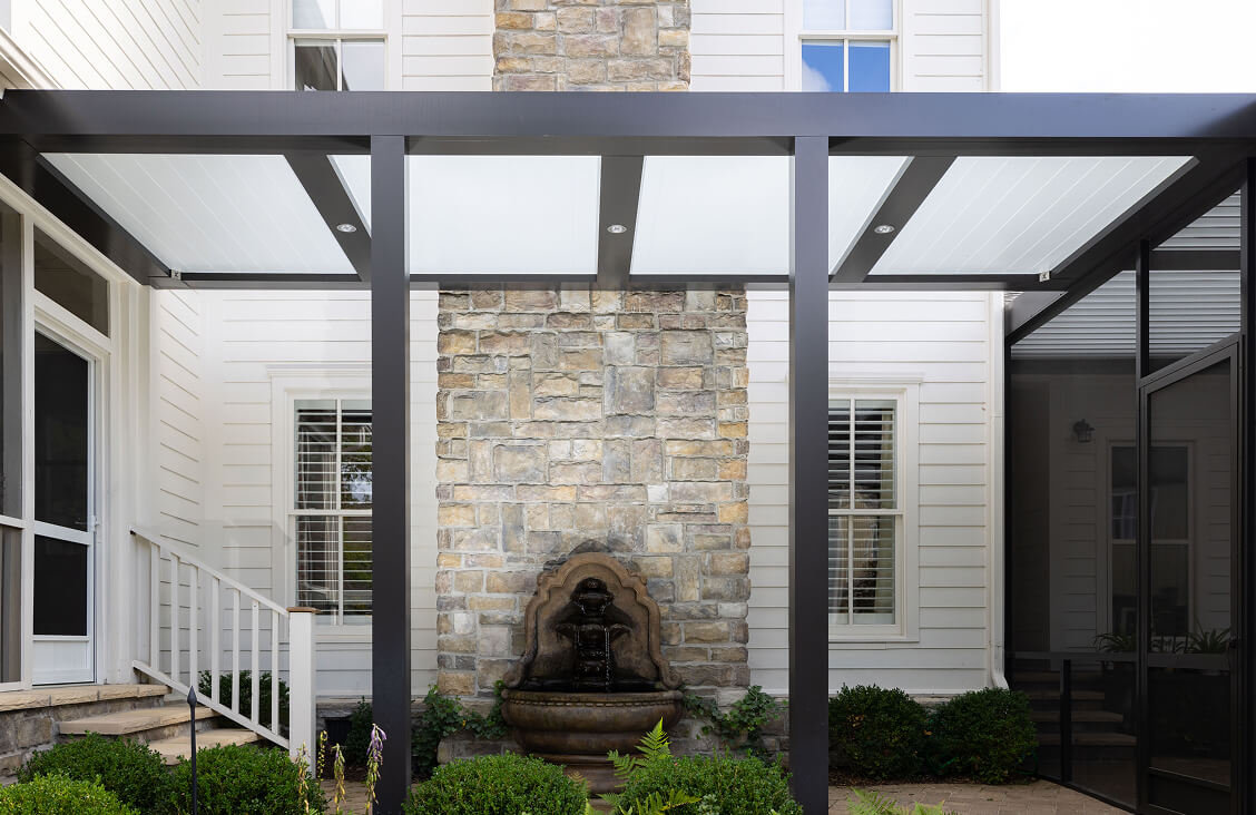 Black and white Pergola X with Pan 6 canopy on the back of white house