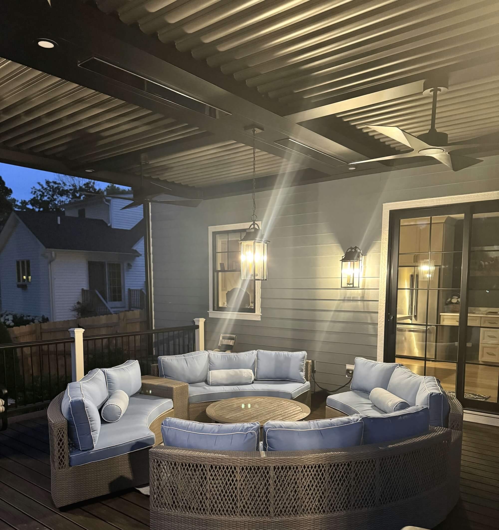 Pergola XL Patio scene features a curved wicker sectional sofa and fire pit table