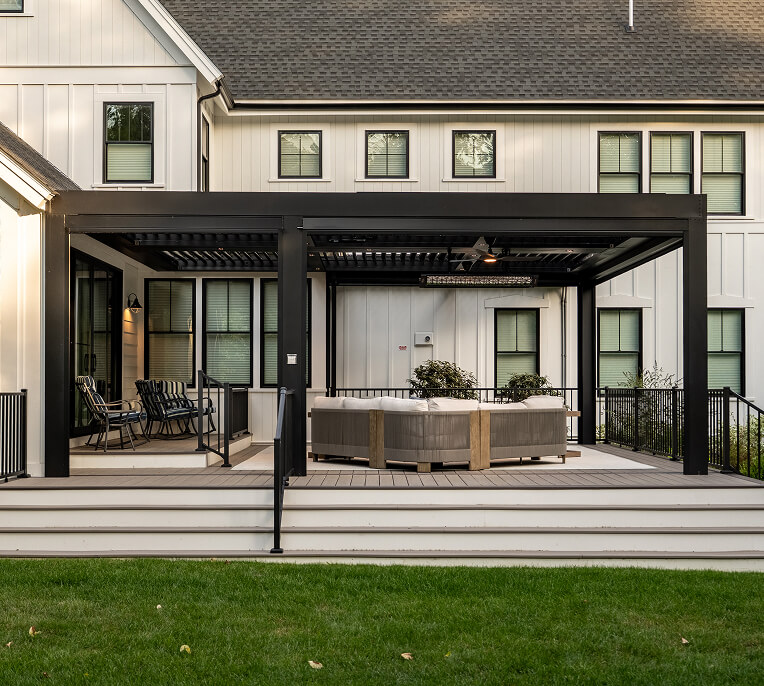 Black Pergola in the backyard of a white house