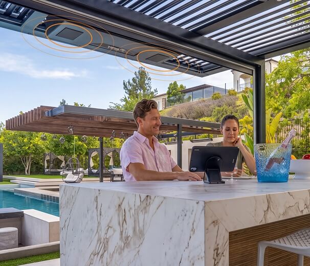 Two people sitting under a pergola listening to music
