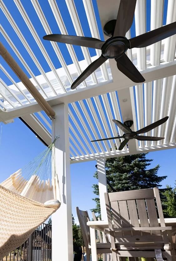 Fans installed on a white pergola with a hammock underneath