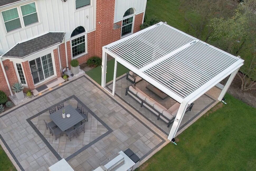 Freestanding StruXure Pergola X with adjustable louvers over a modern backyard lounge