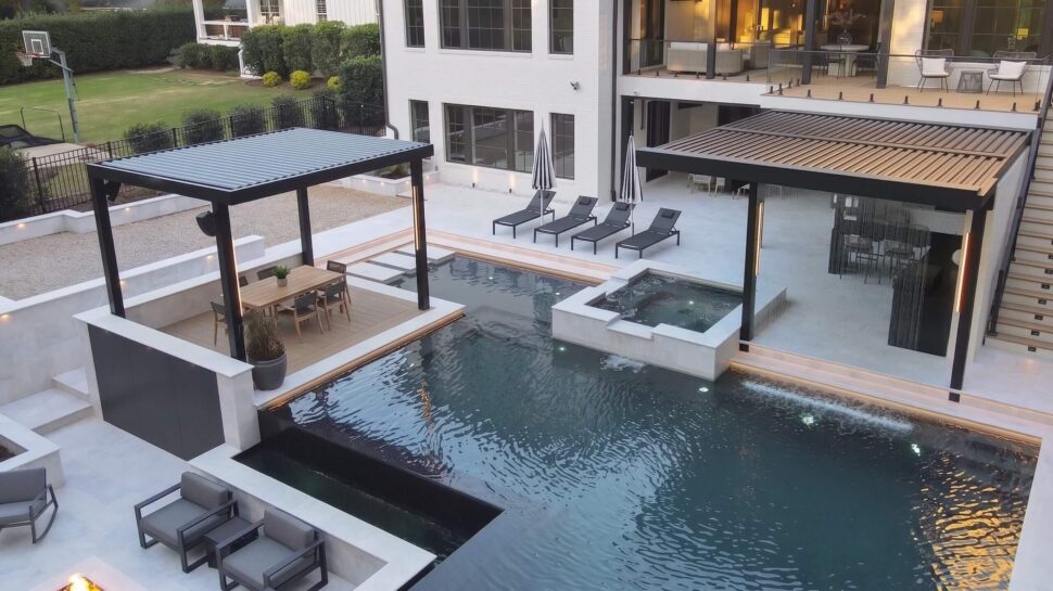 StruXure Pergola X with blue curtains covering a landscaped backyard patio