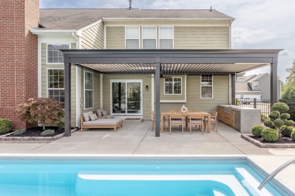 White StruXure Pergola X shading a lakefront outdoor kitchen and dining space
