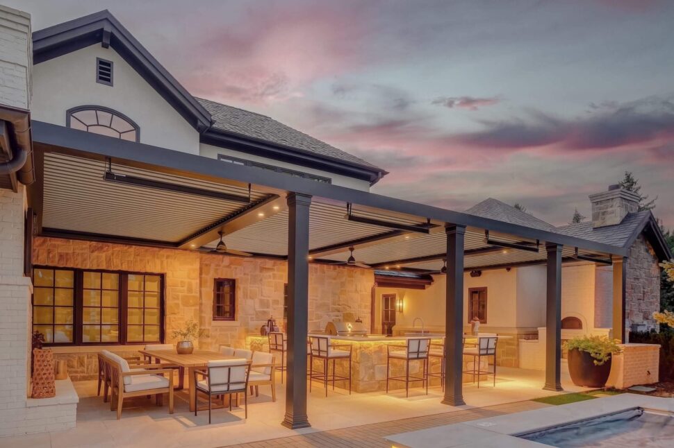 Illuminated StruXure Pergola X with warm-toned louvers over a raised deck seating area