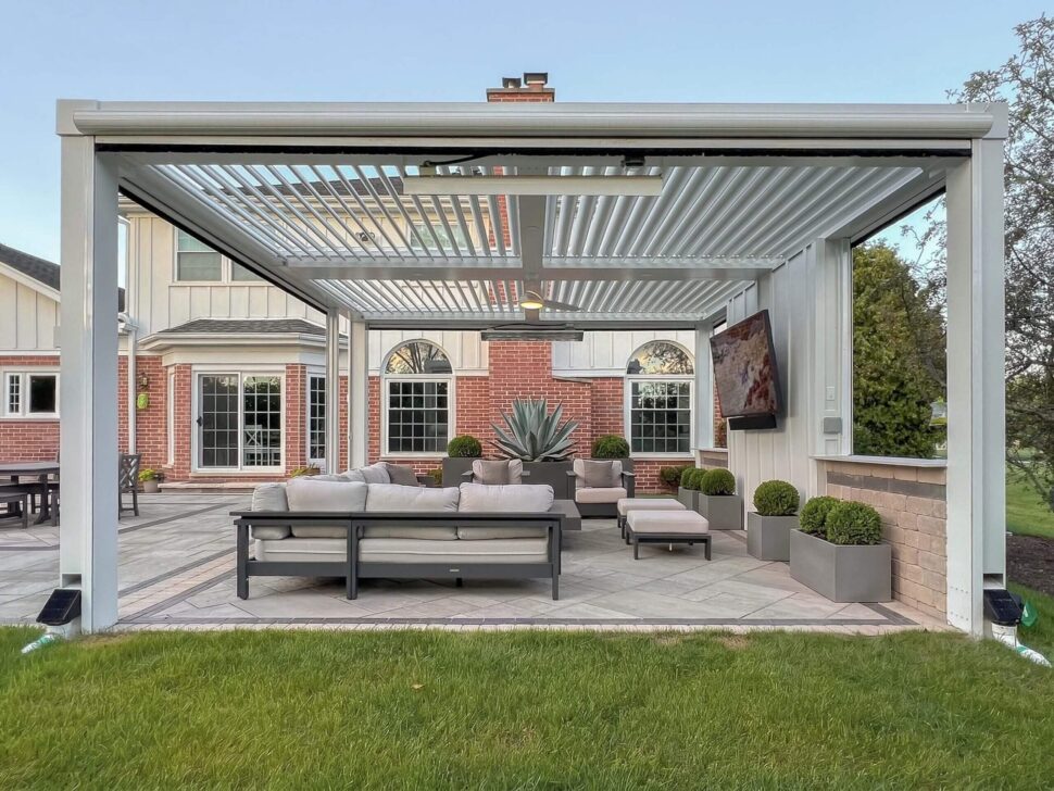 White StruXure Pergola X louvered roof with ceiling fans above a furnished patio