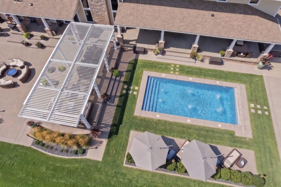 StruXure Pergola X extending across a modern home patio beside a swimming pool